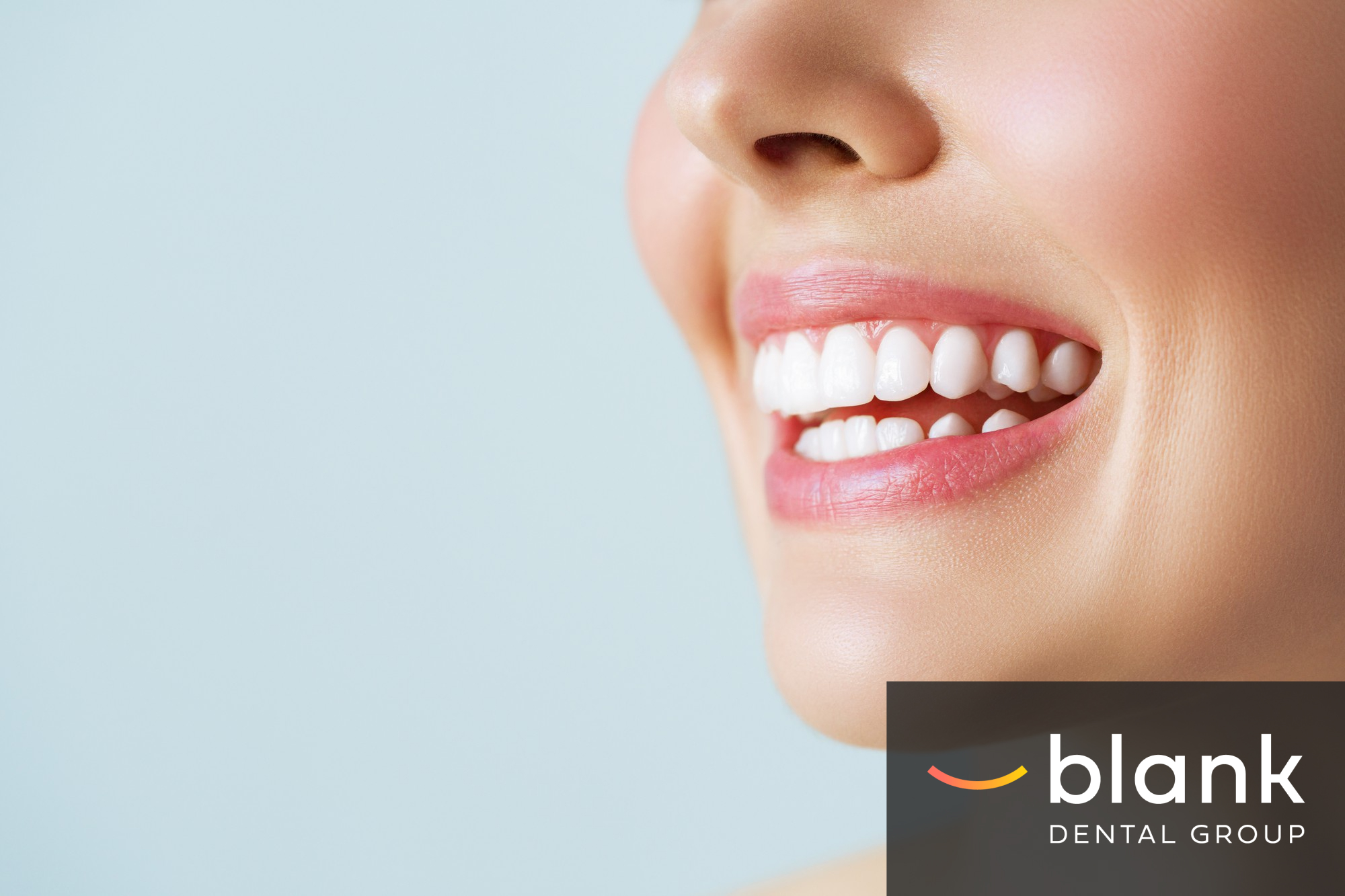 A close-up of a smiling patient with bright teeth at Blank Dental Group.